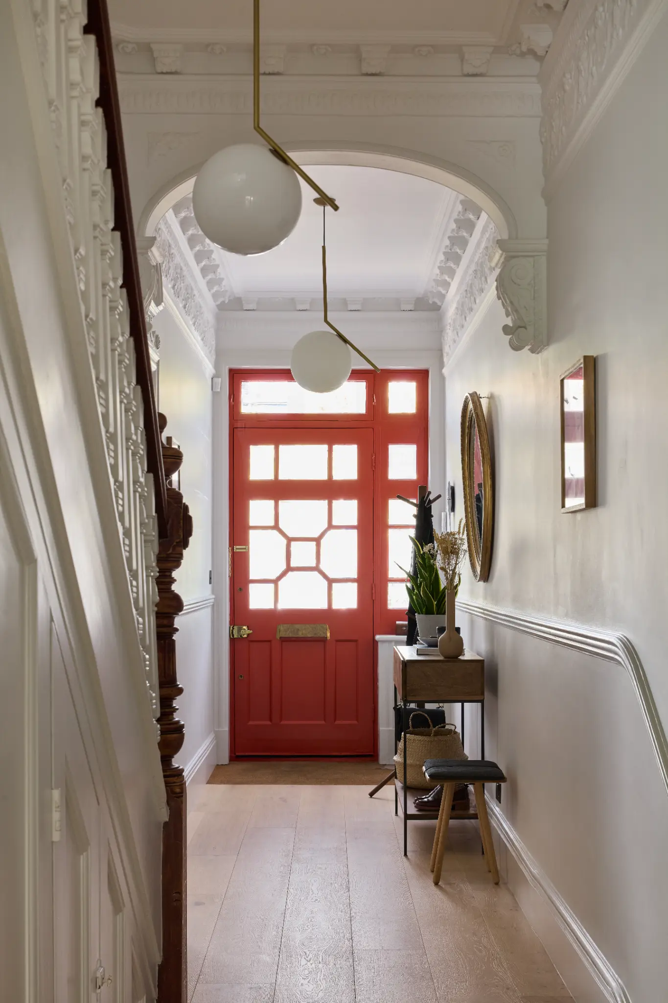 Period entrance corridor with elegant red door and plaster detailing